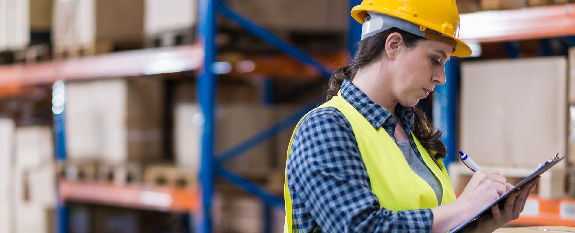 Femme réalisant un audit de sécurité d'un entrepôt logistique