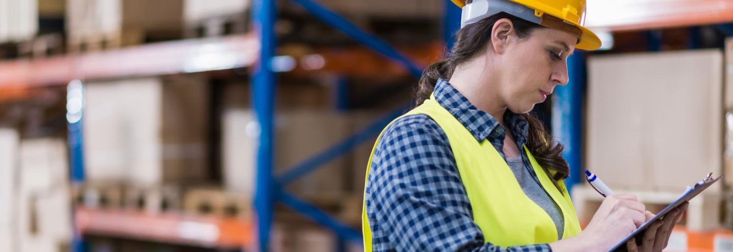 Femme réalisant un audit de sécurité d'un entrepôt logistique