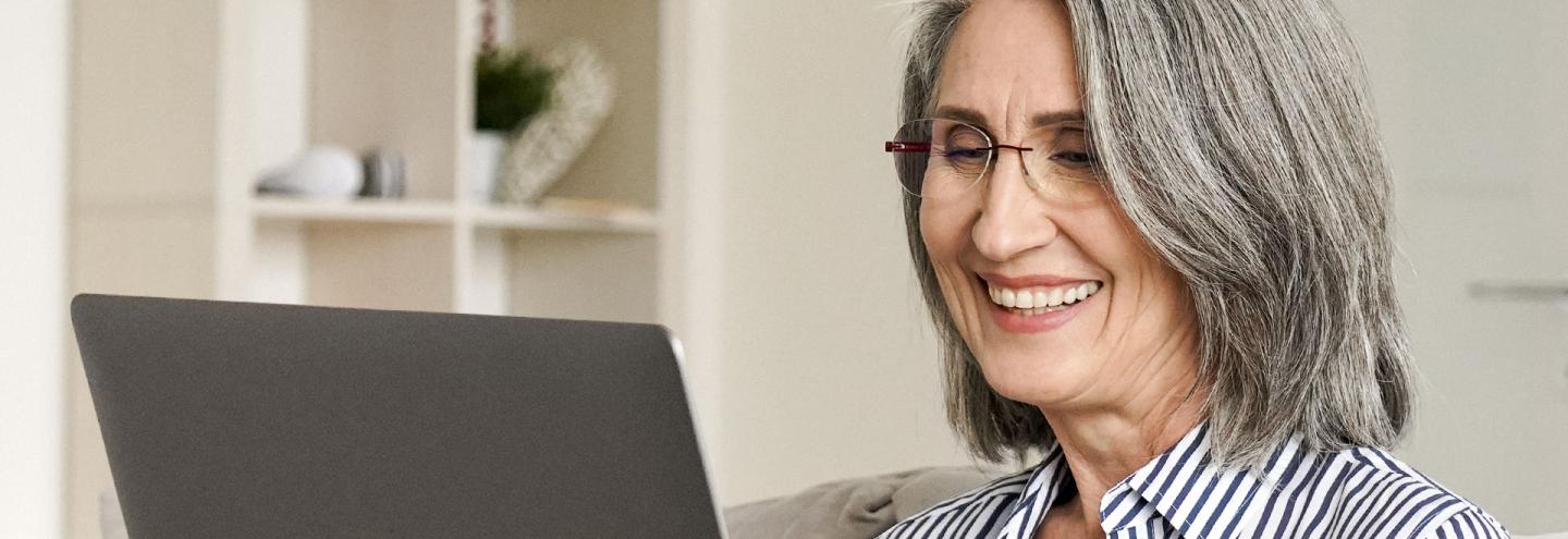 Femme de 60 ans préparant sa retraite en ligne