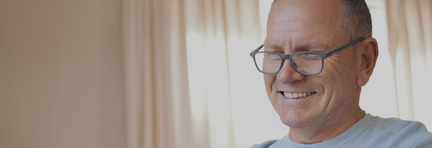 Homme souriant de 50 ans qui se renseigne sur sa retraite