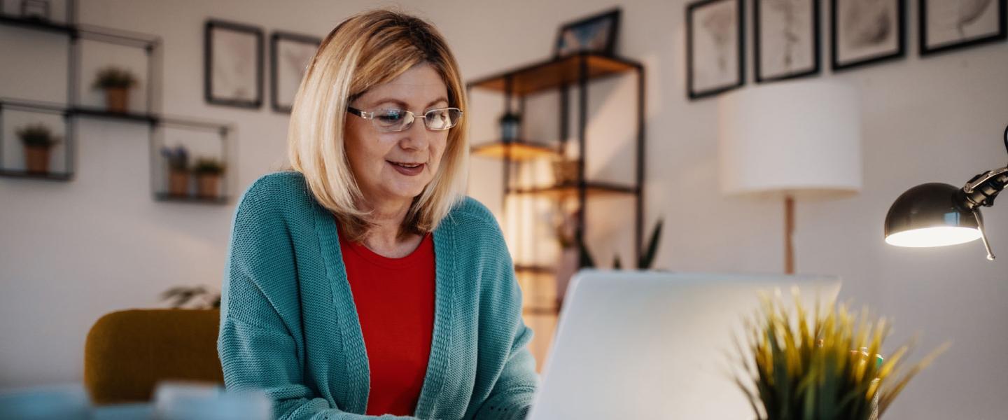 Femme de 60 ans qui fait sa demande de retraite en ligne